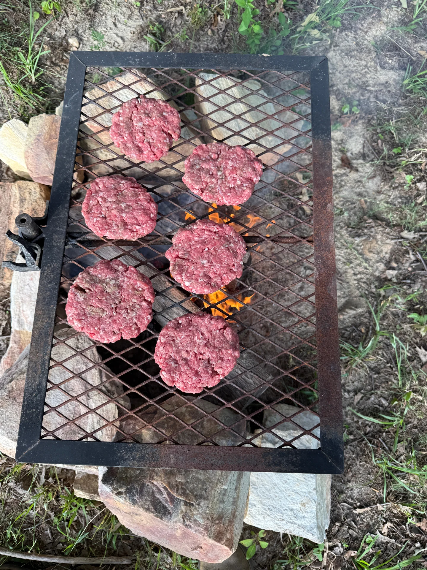 River Cade Farms burgers cooking over a fire